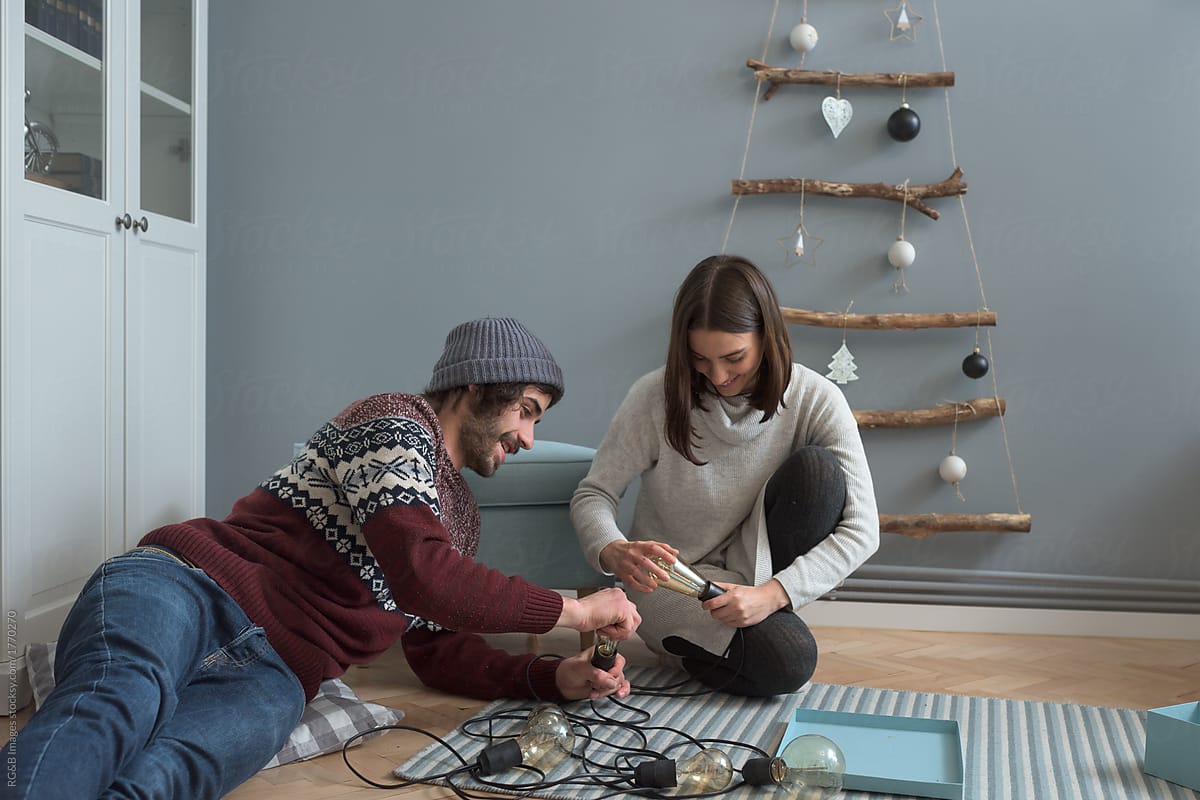 Beautiful creative couple doing handicrafts for Christmas at home