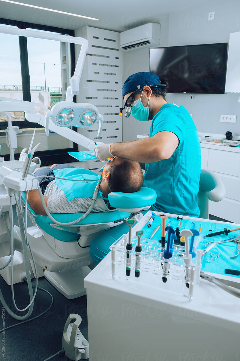 Dentist and patient in ordination during dental examination.