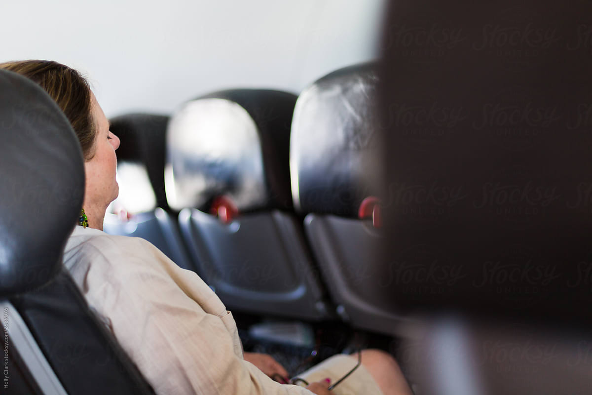 Side view of woman seated in airplane.