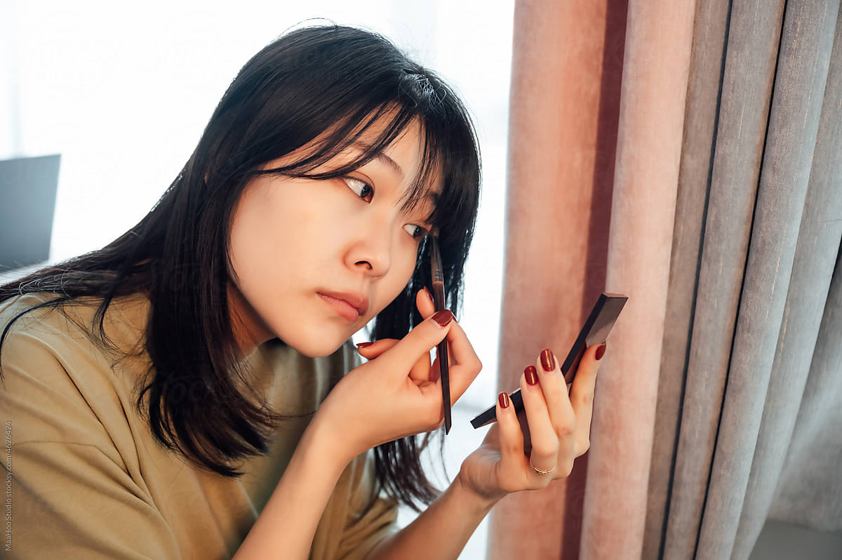 Young woman applying makeup in the morning