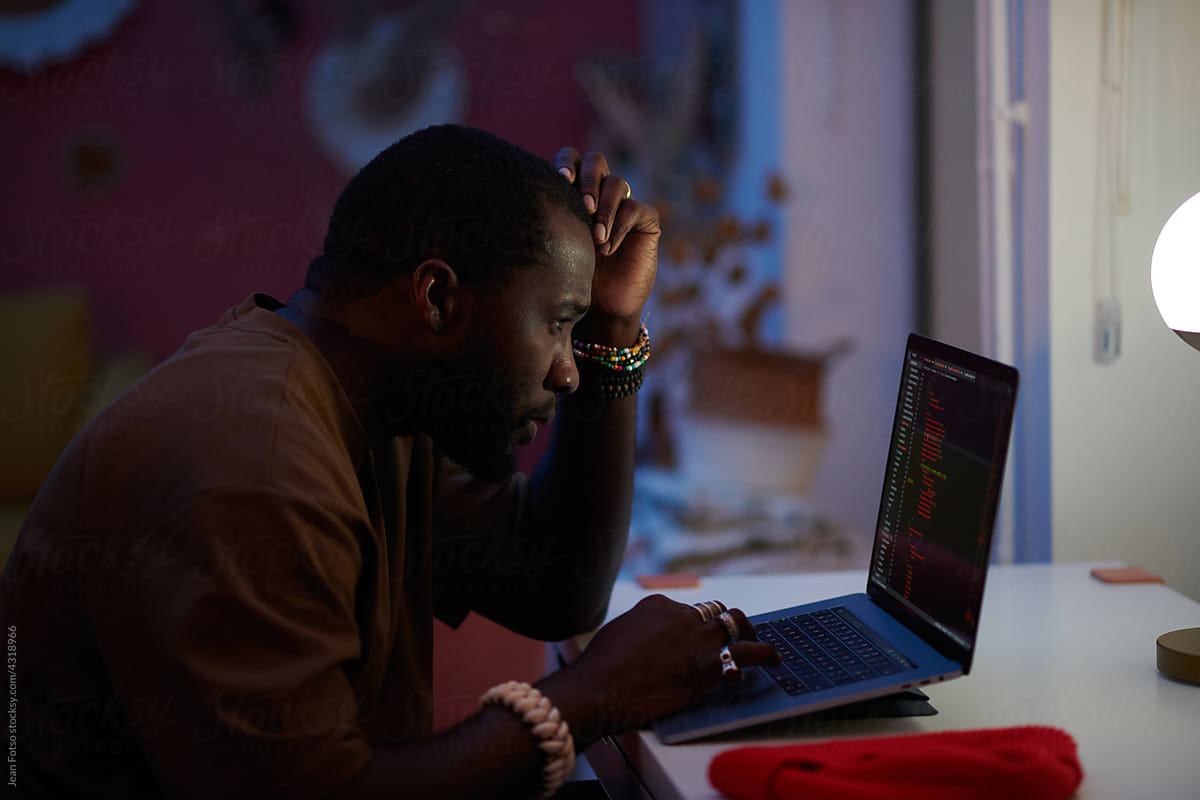 concentrate black man  coding on his laptop