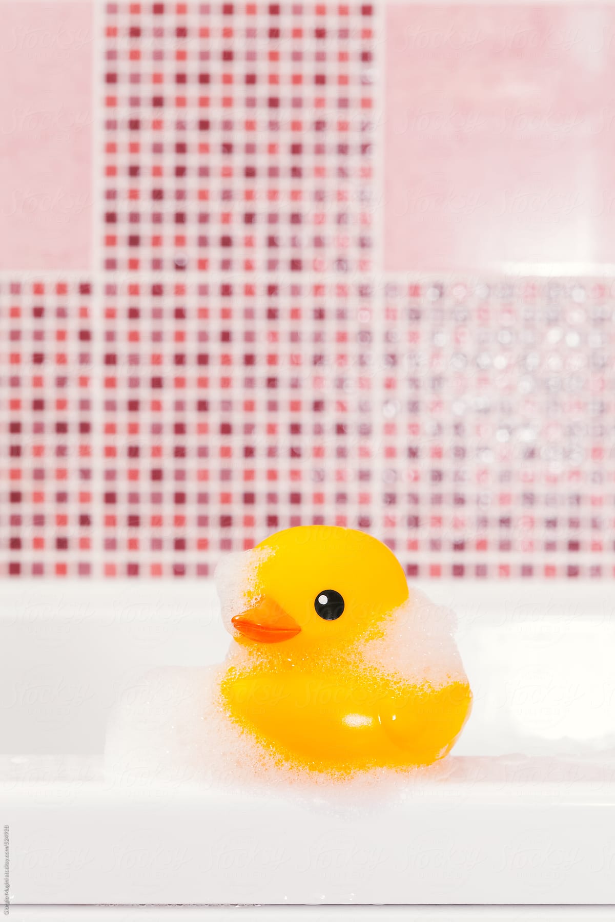 Rubber Duck Toy with Soap Foam in the Bathtub