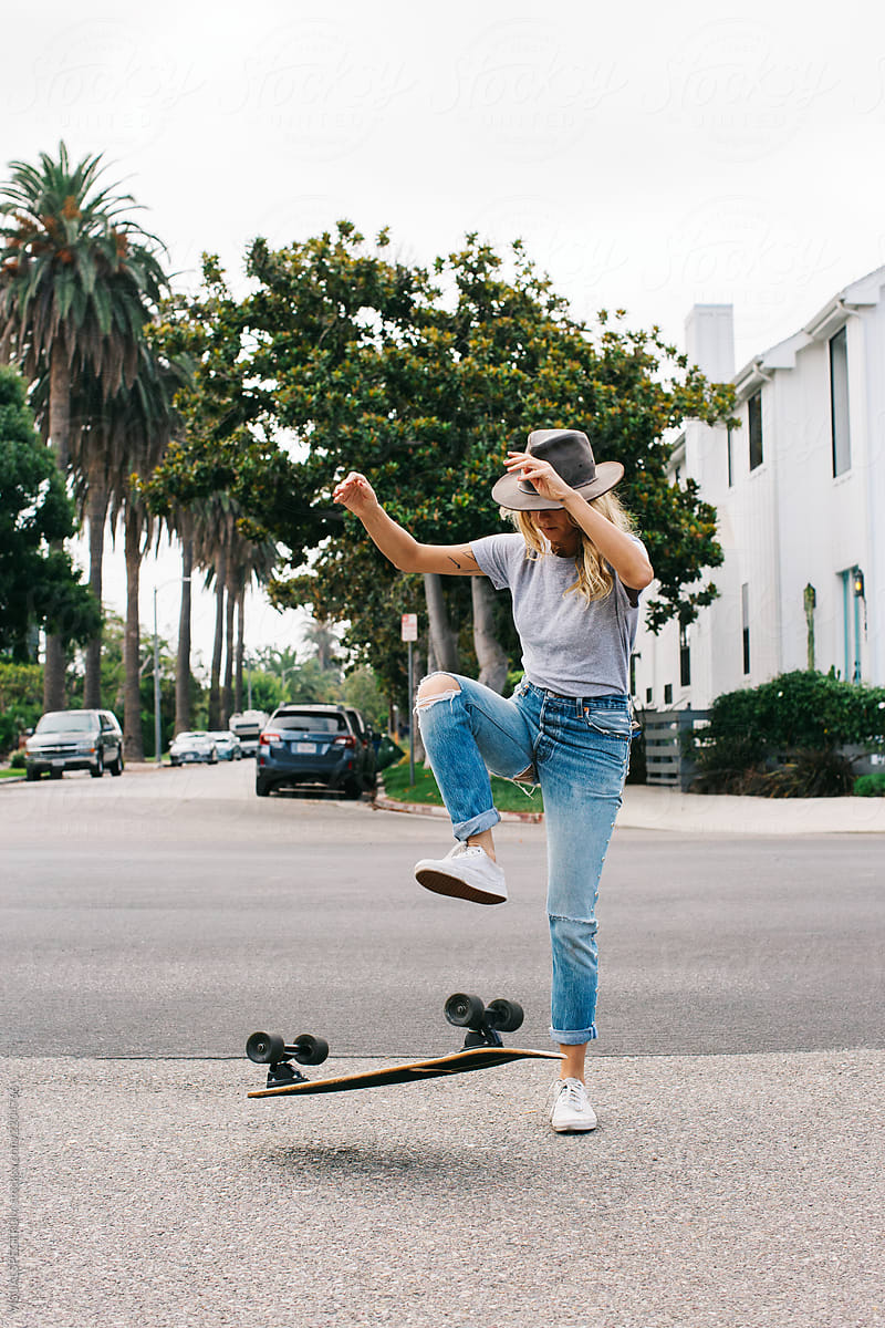 Young Pretty Blonde Doing Skateboard Tricks in Venice Street