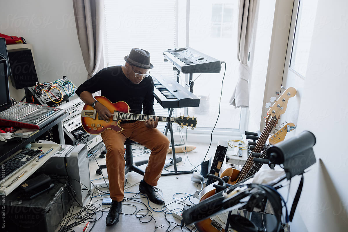 Man playing music in his studio room.
