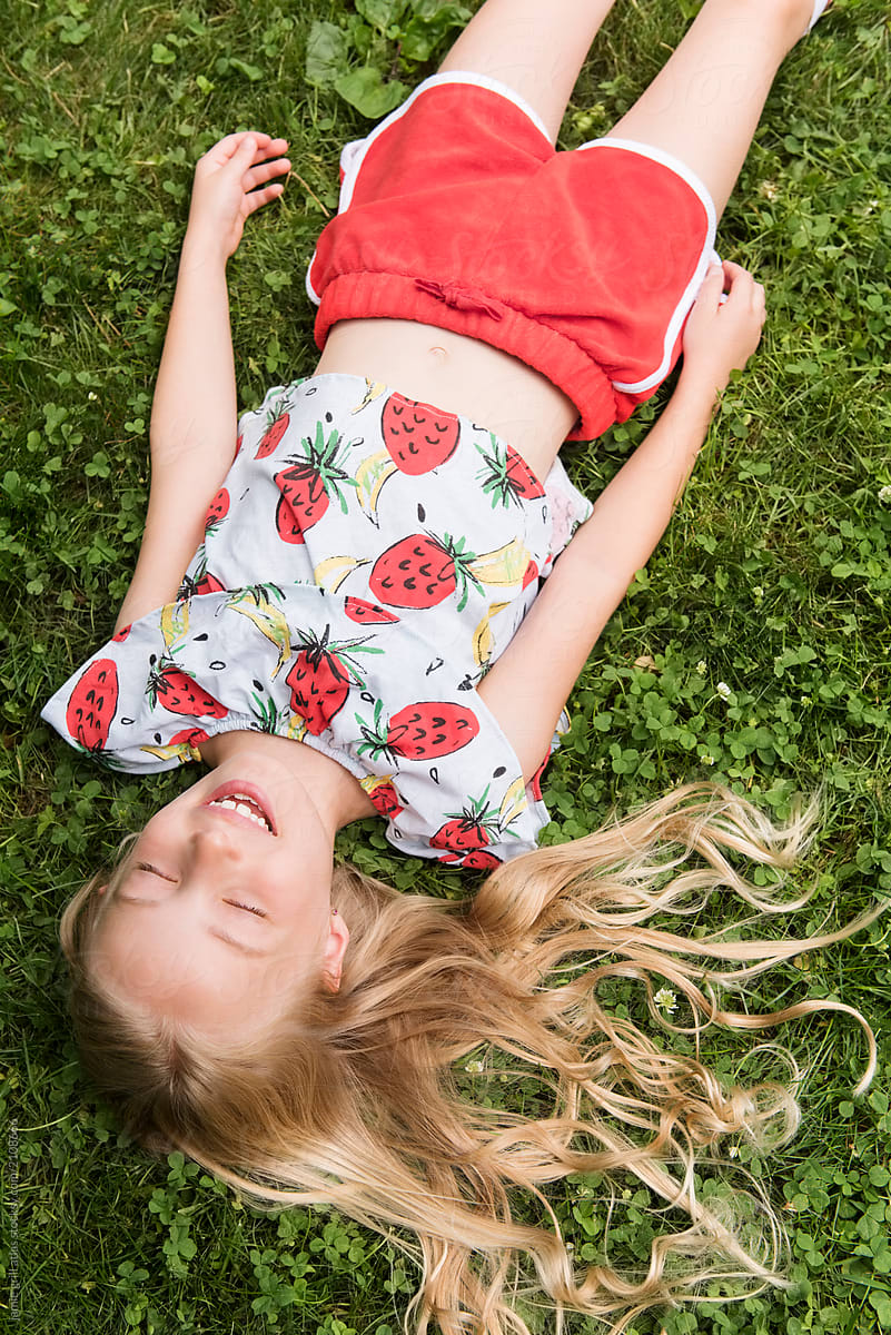 Girl Lying In Grass Laughing By Stocksy Contributor Jamie Grill 