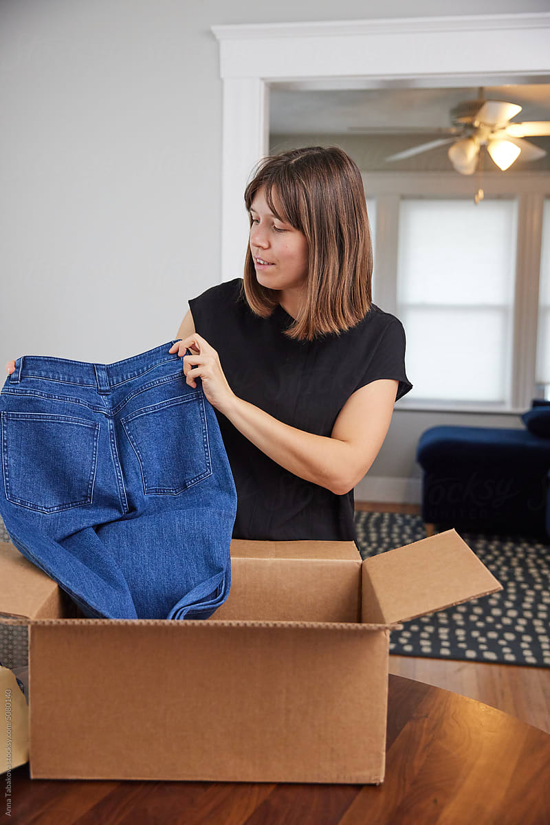 Woman opening a shipment with new jeans