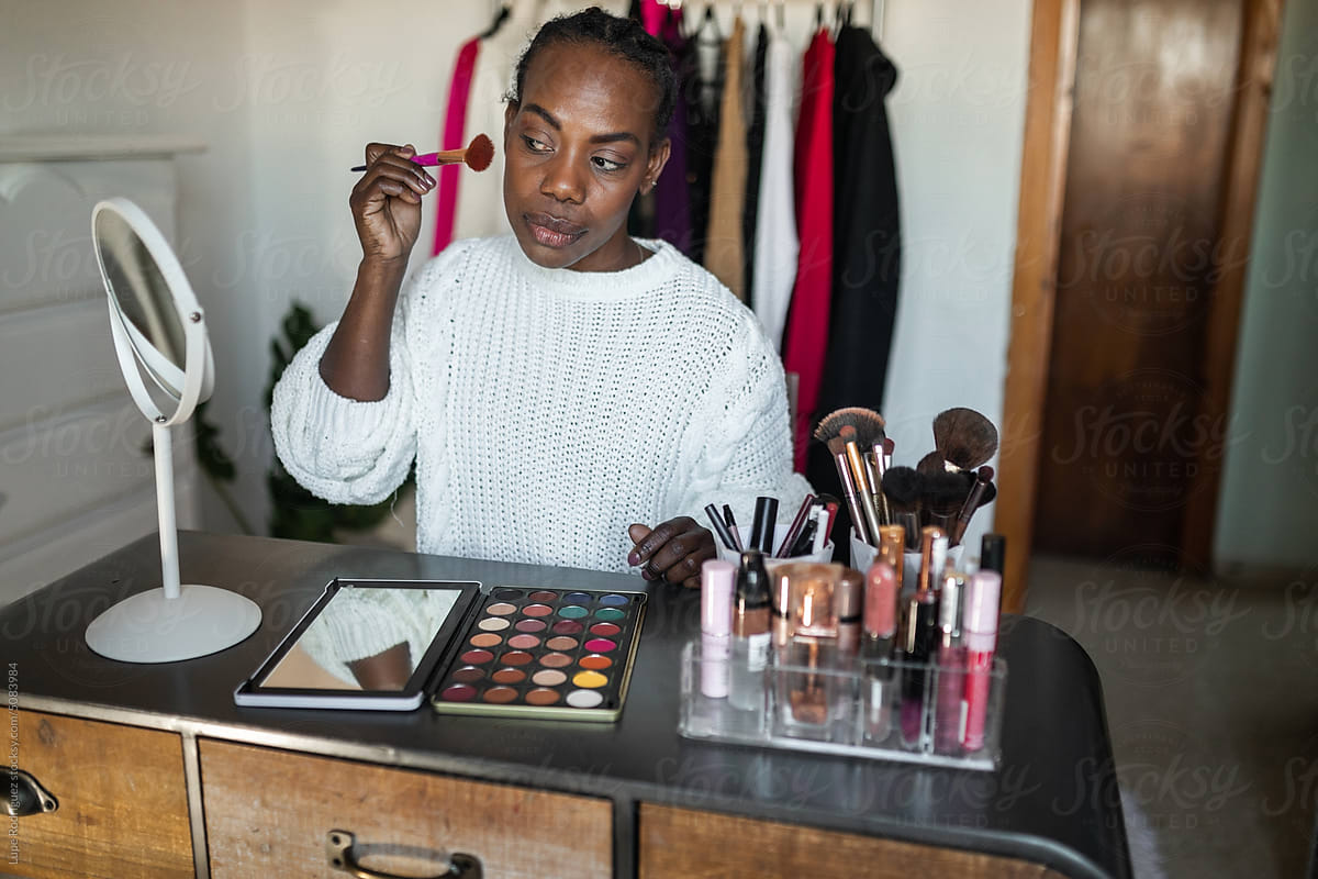 black woman doing makeup at home