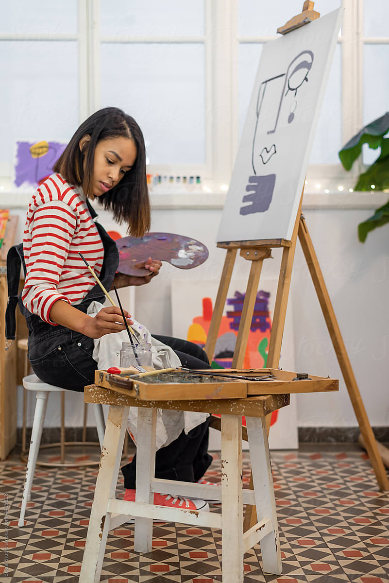 Woman painting on easel in workshop
