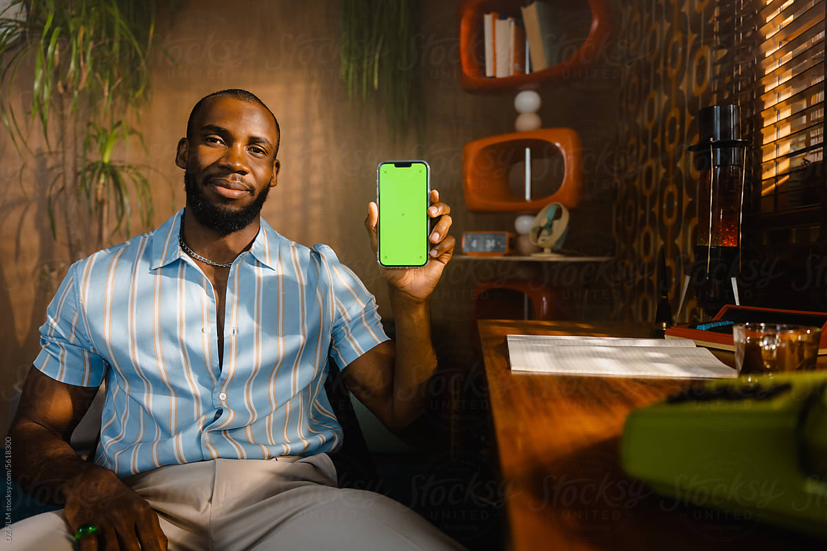 A man with a green-screen phone in the office