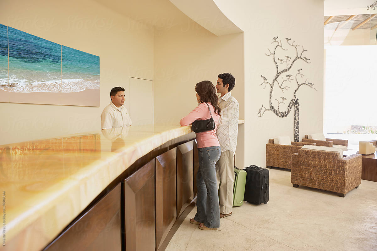 Guests arriving at luxury hotel reception front desk