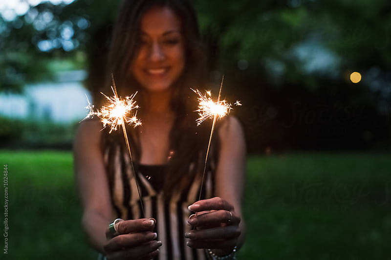 Woman holding sparkle sticks
