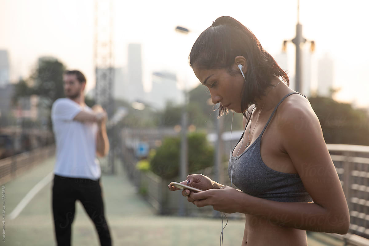 Woman choosing music on phone to exercise to
