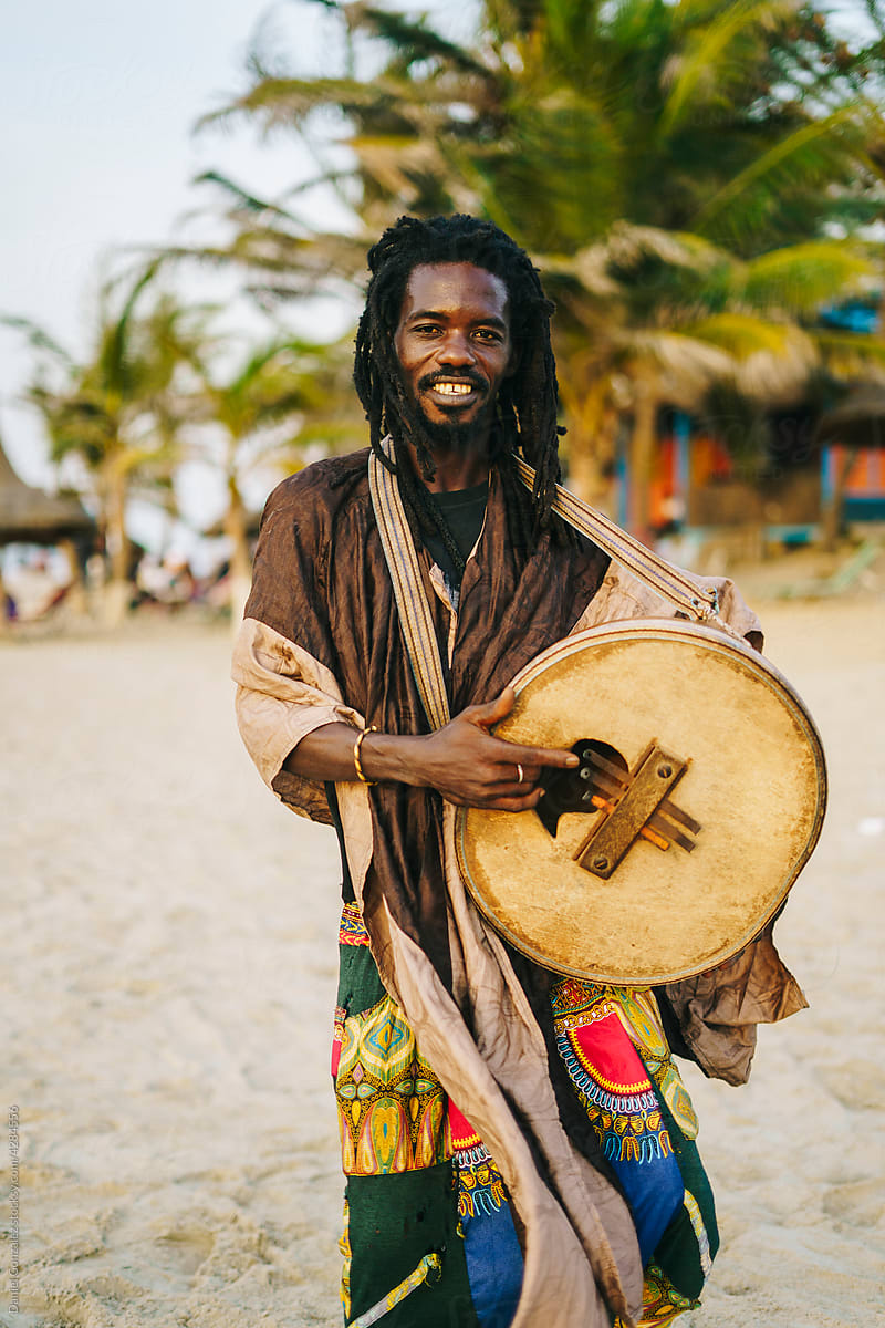 African man playing mbira on shore