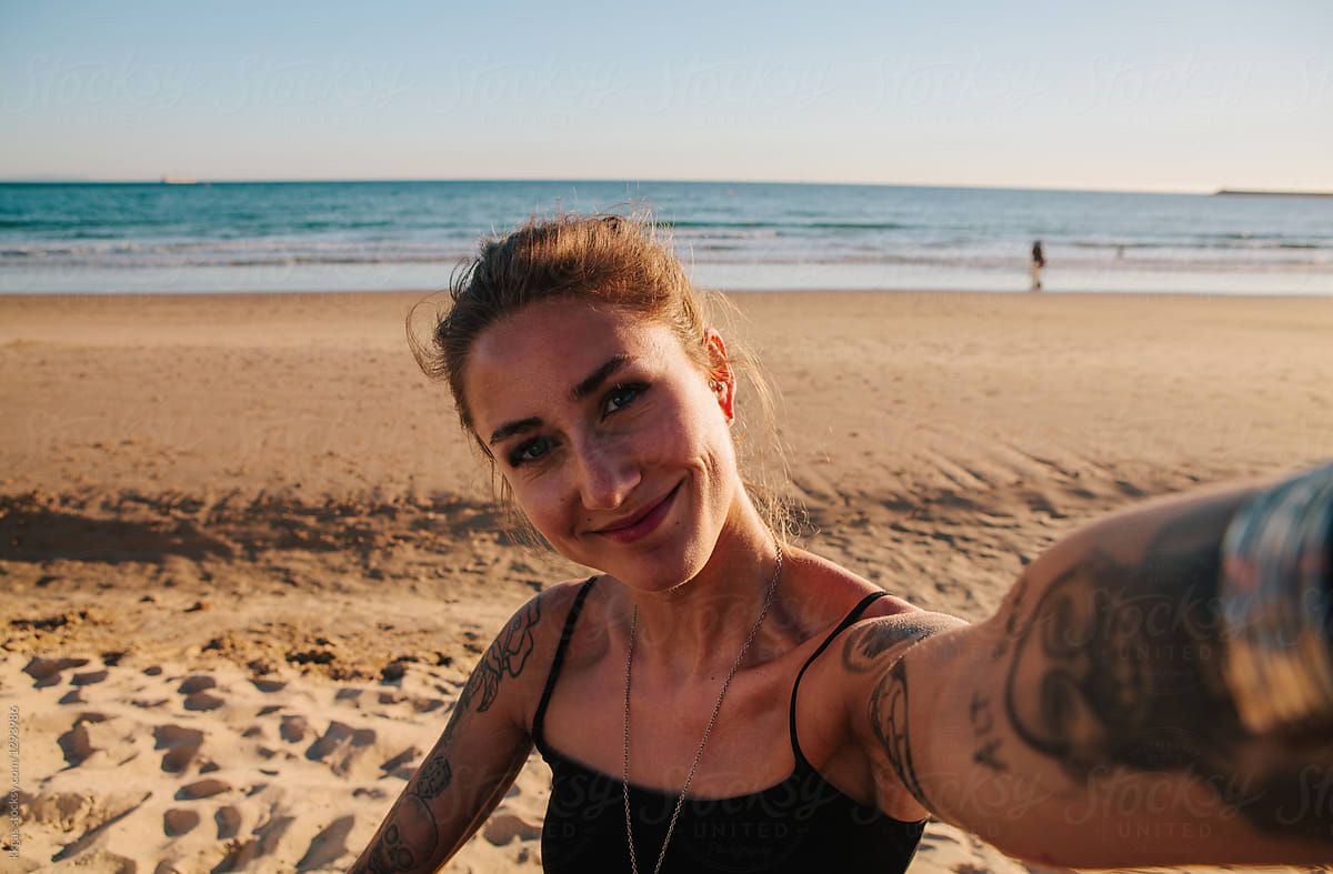 Tattooed woman beach selfie