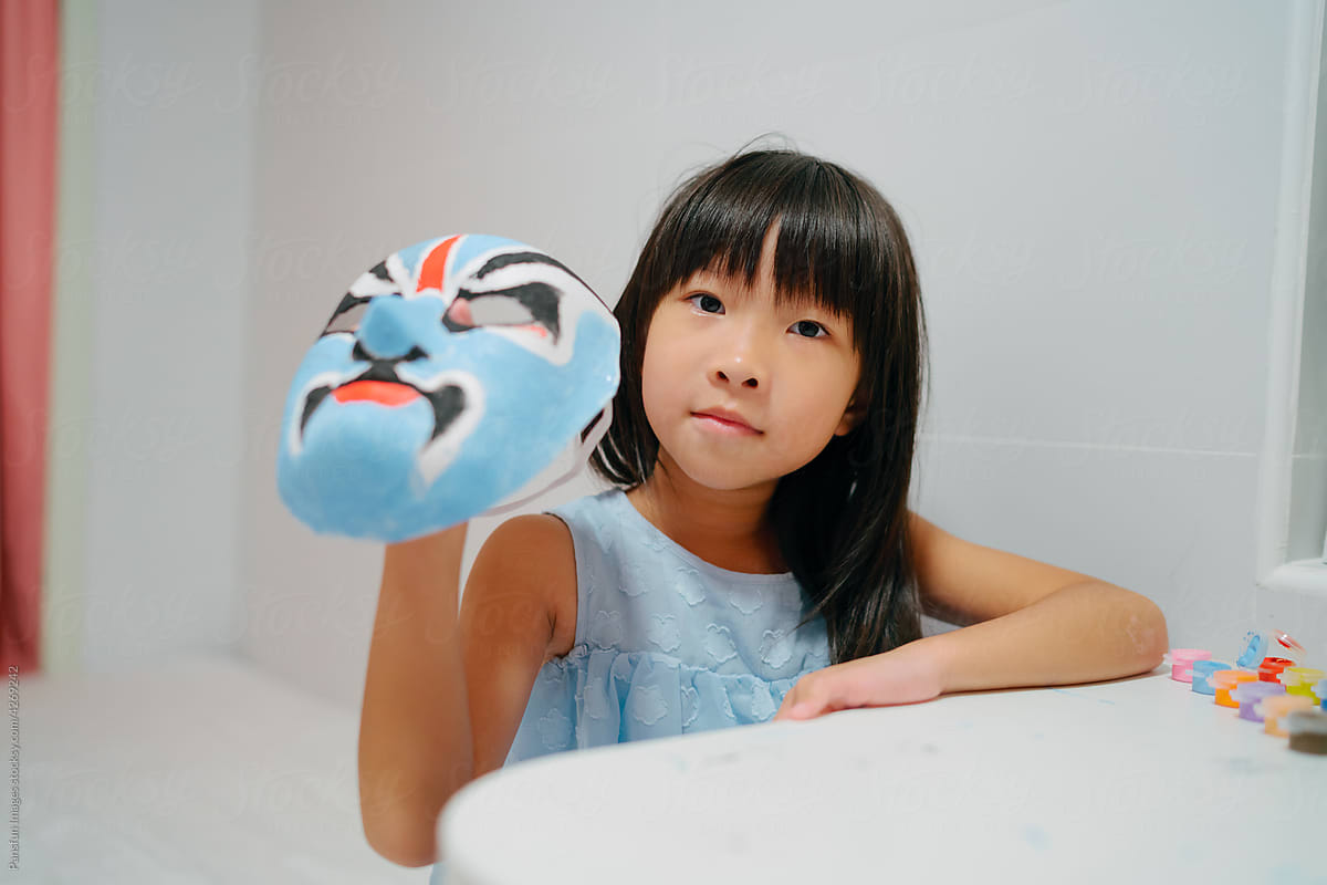 Asian child with a painting opera mask