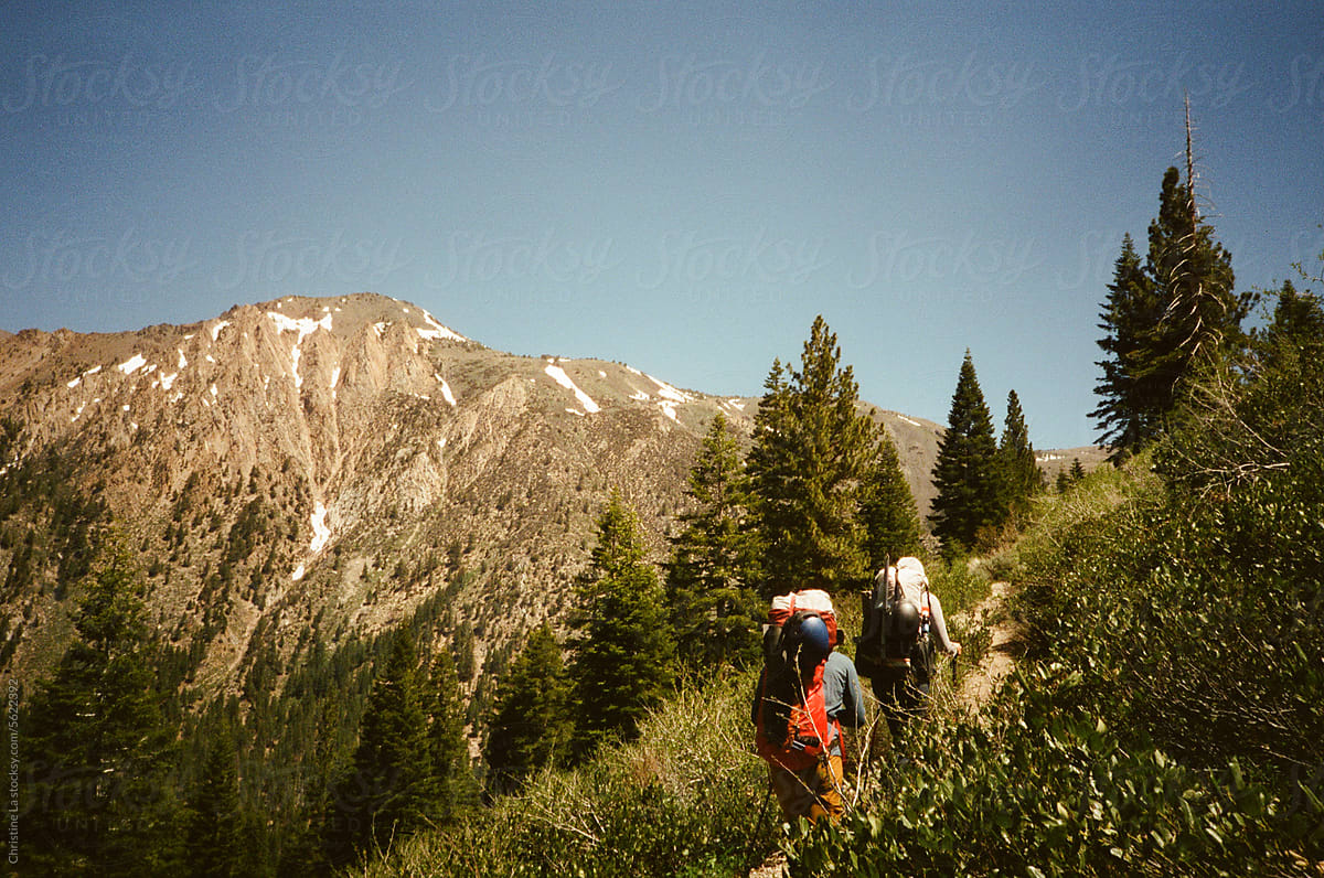 Two backpackers hiking on a trail.