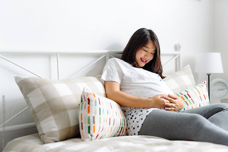 Pregnant woman having a rest on bed