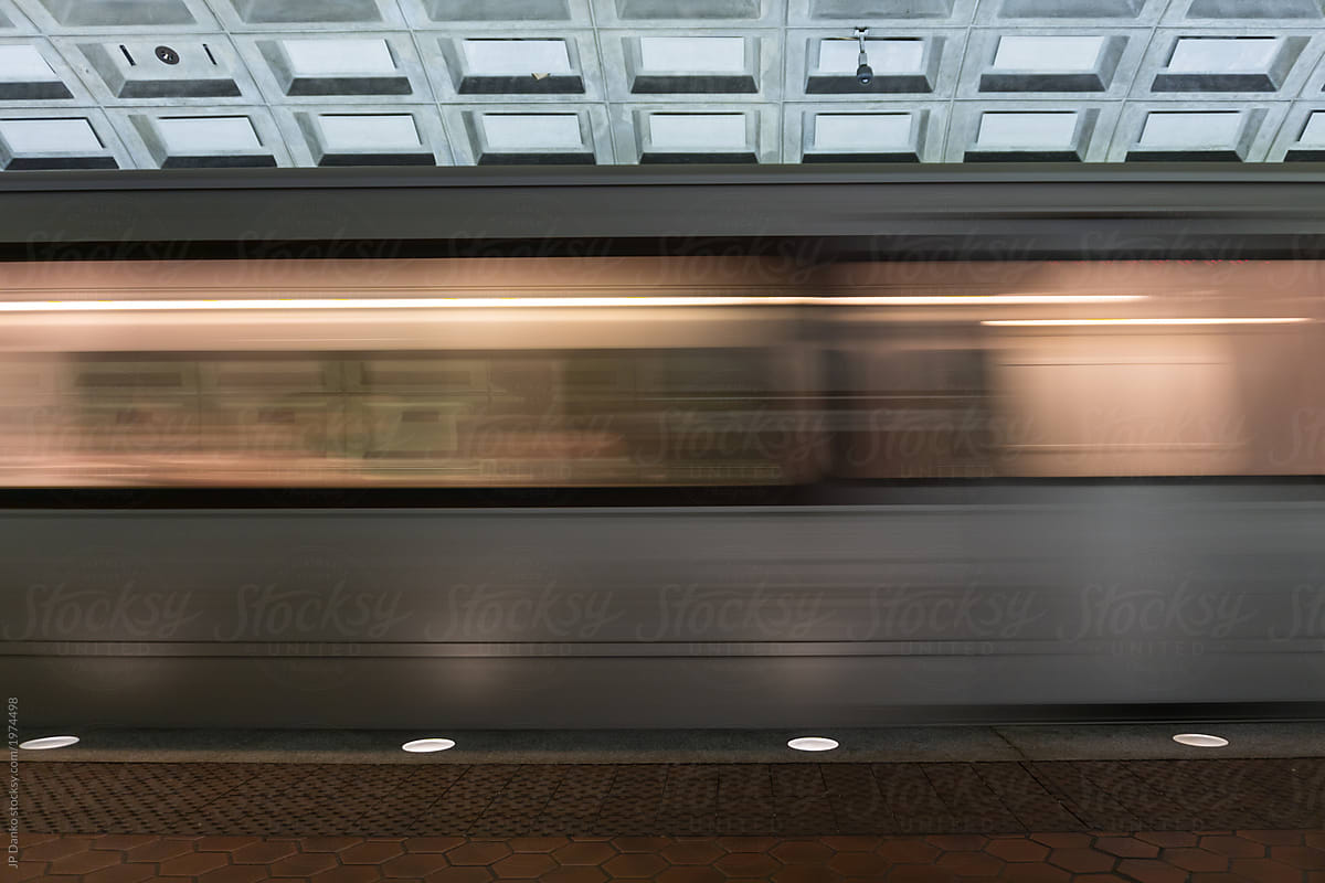 Subway train speeds through station taking commuters to their destination