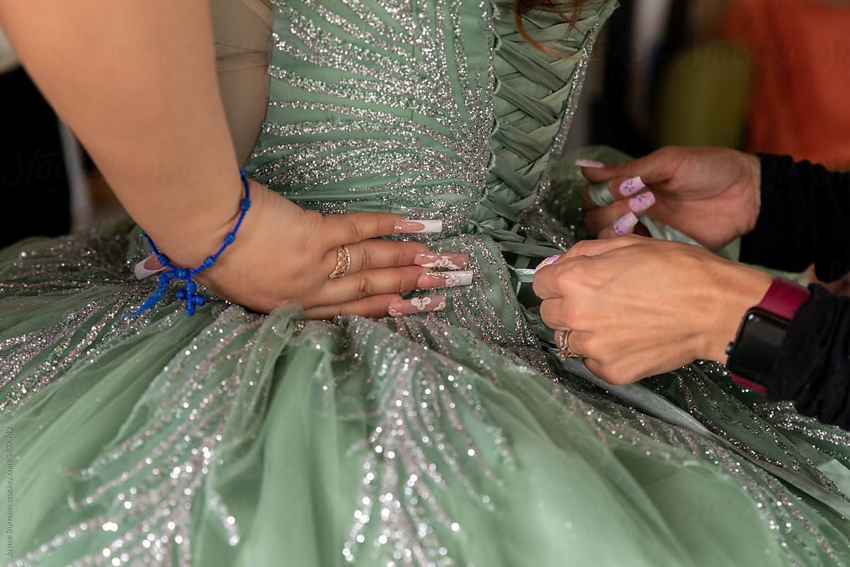 Girl Getting Gown Laced up for Quinceanera