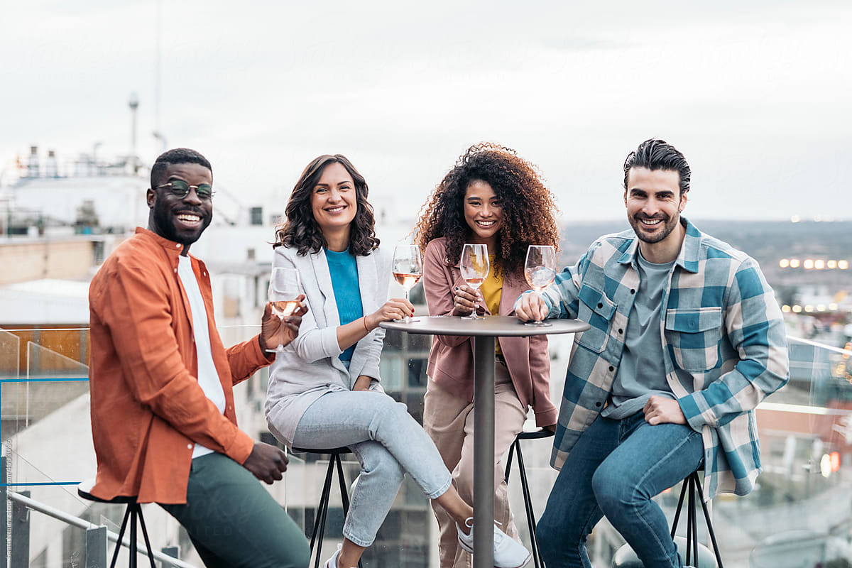 Cheerful multiethnic friends standing on rooftop