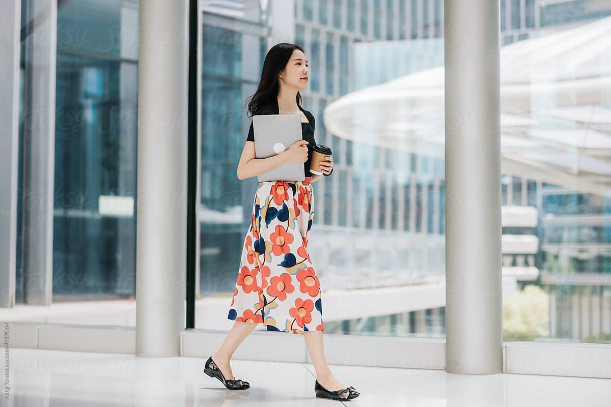 Asian office lady walking in the modern city building.