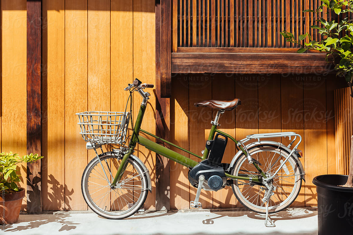 Green Bicycle Parked Against Wooden Wall