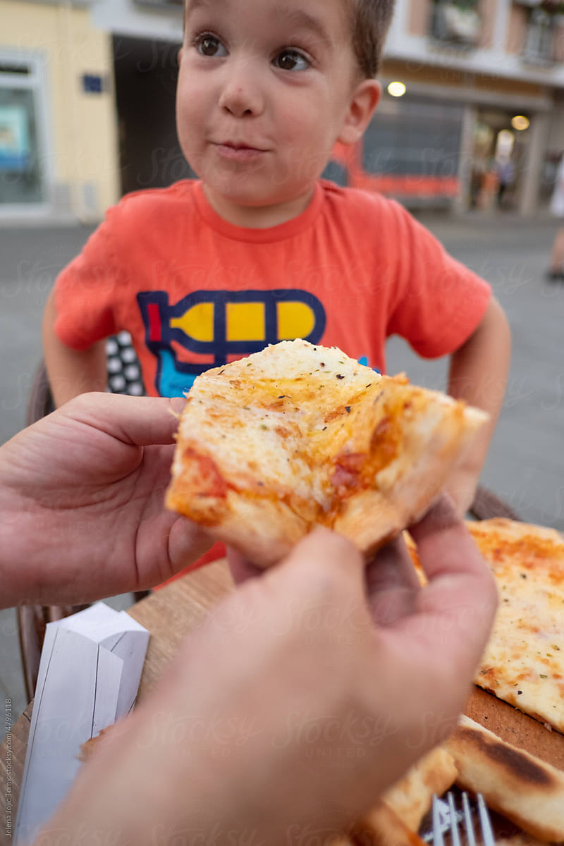 Toddler is excited about the pizza slice