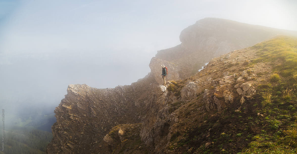 Hiker on foggy cliffs