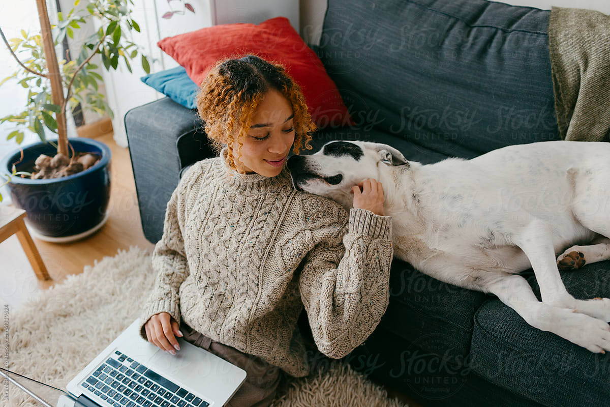 Girl bonding with dog at home living room