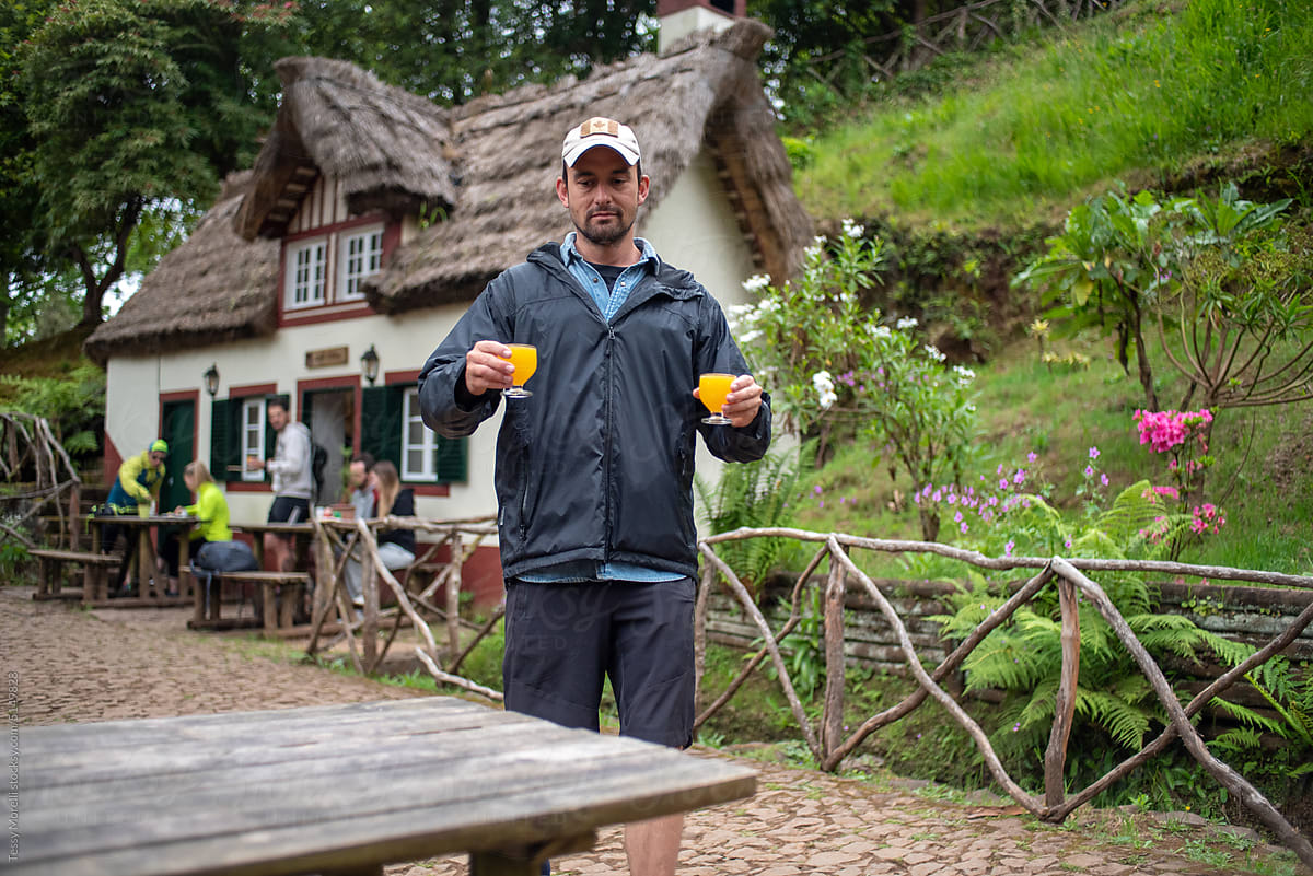 Man hiking in Madeira Island carrying Poncha drinks