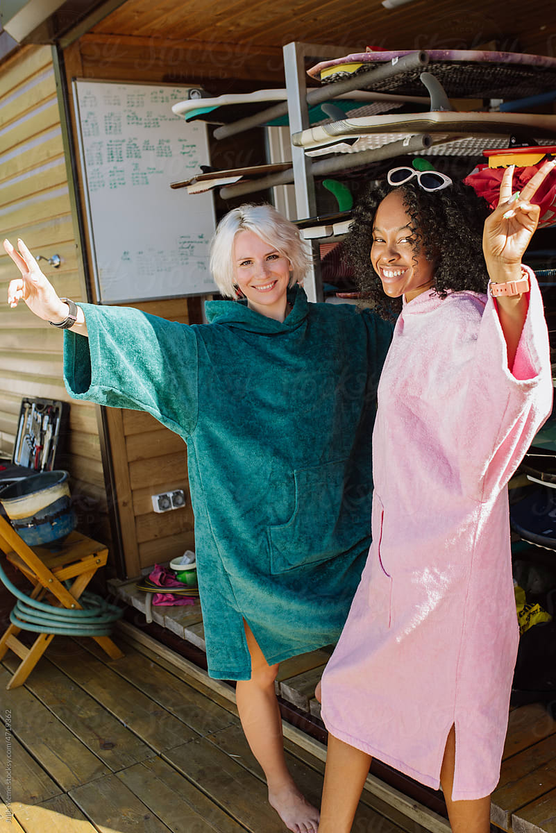 Two Women in Colorful Dresses Smiling and Gesturing Peace Sign