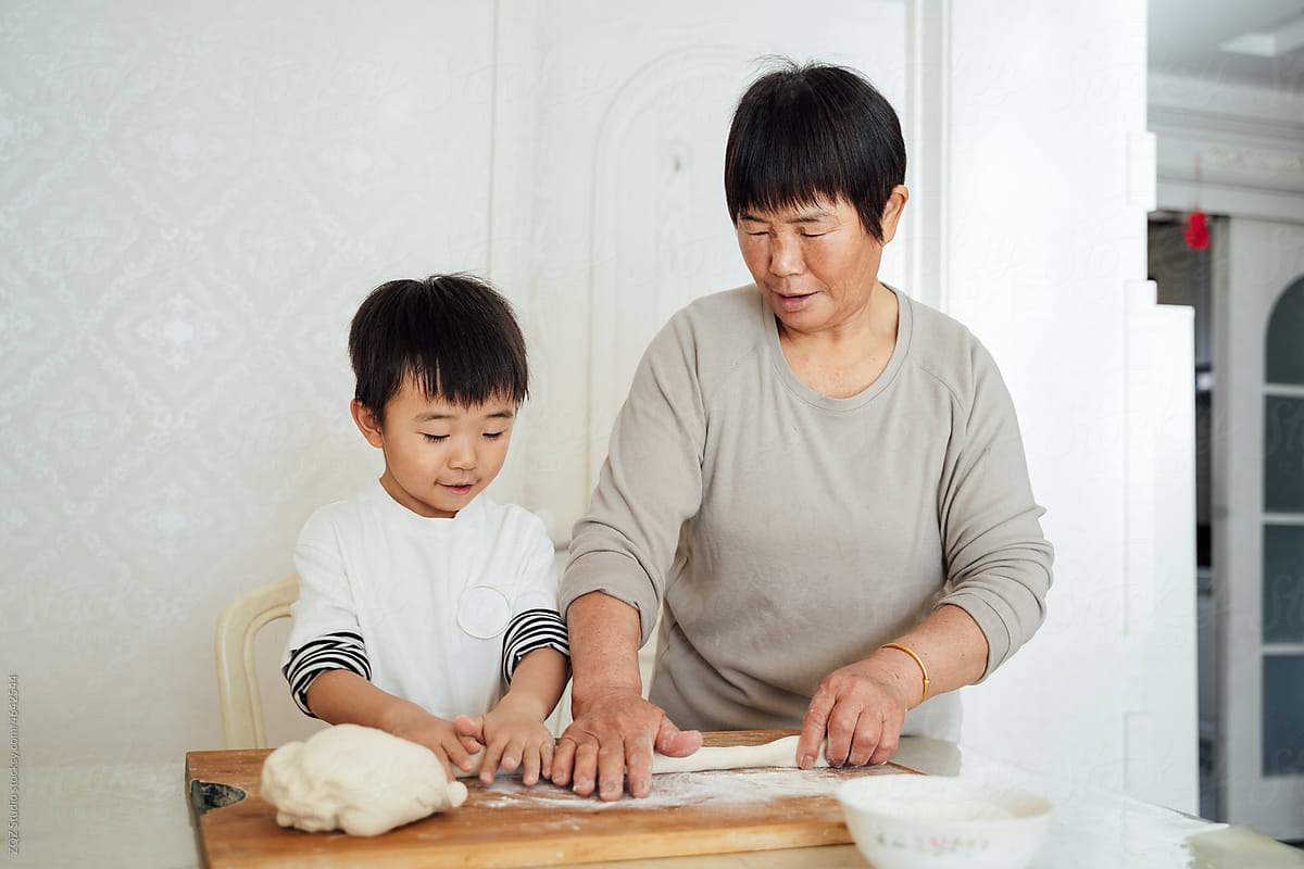 Cute boy cooking with grandma