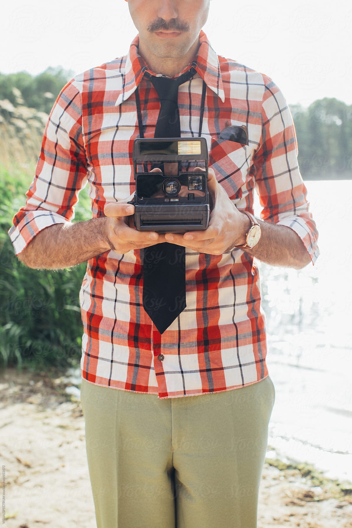 Retro-Styled Male Hipster With Moustache Holding Polaroid Camera in Front of Chest