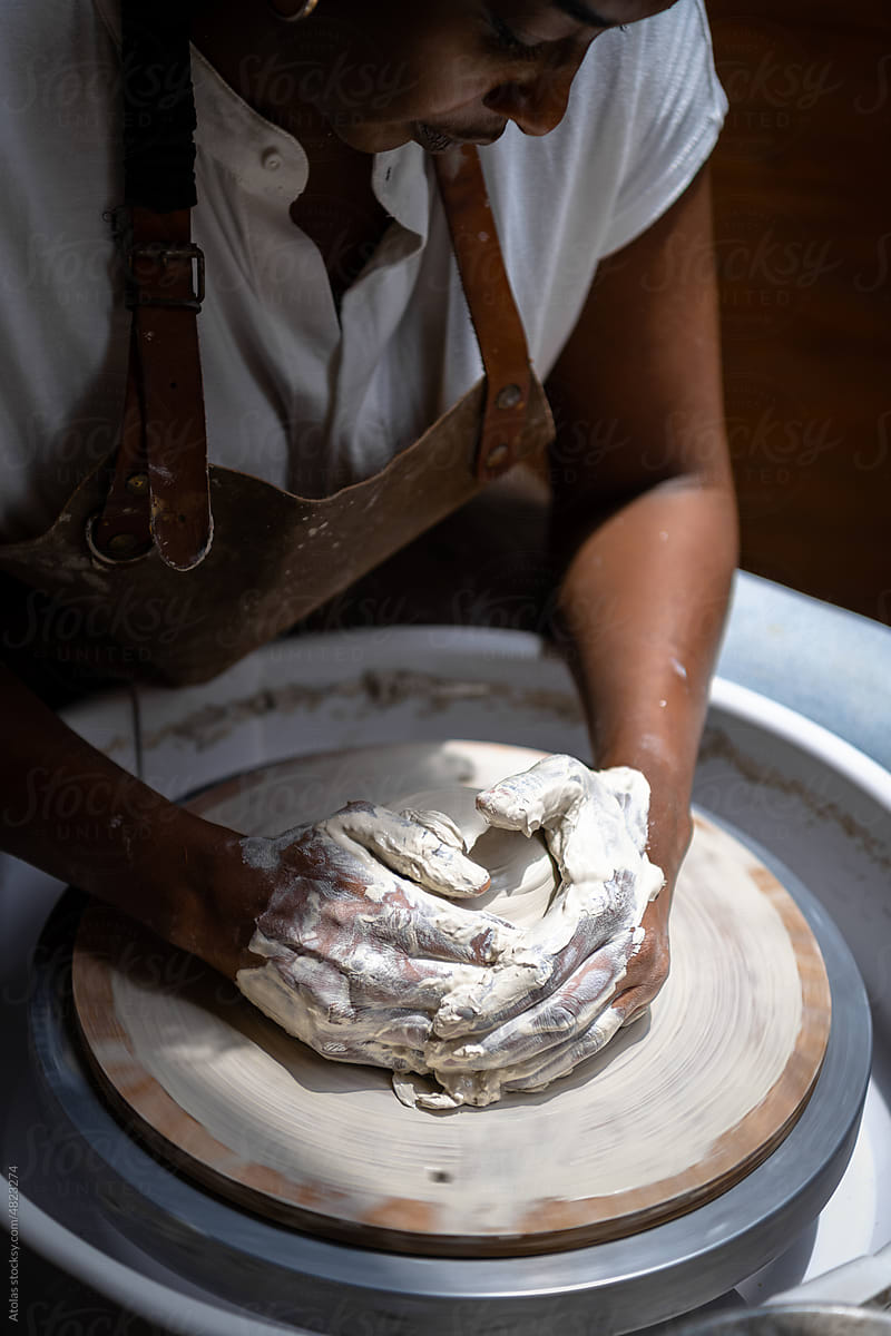 Closeup of woman working with clay on the pottery wheel