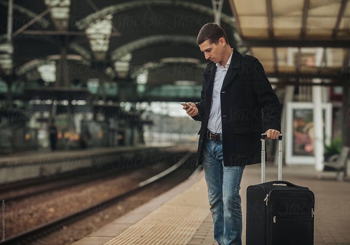 Businessman Checking Smartphone on Train Station