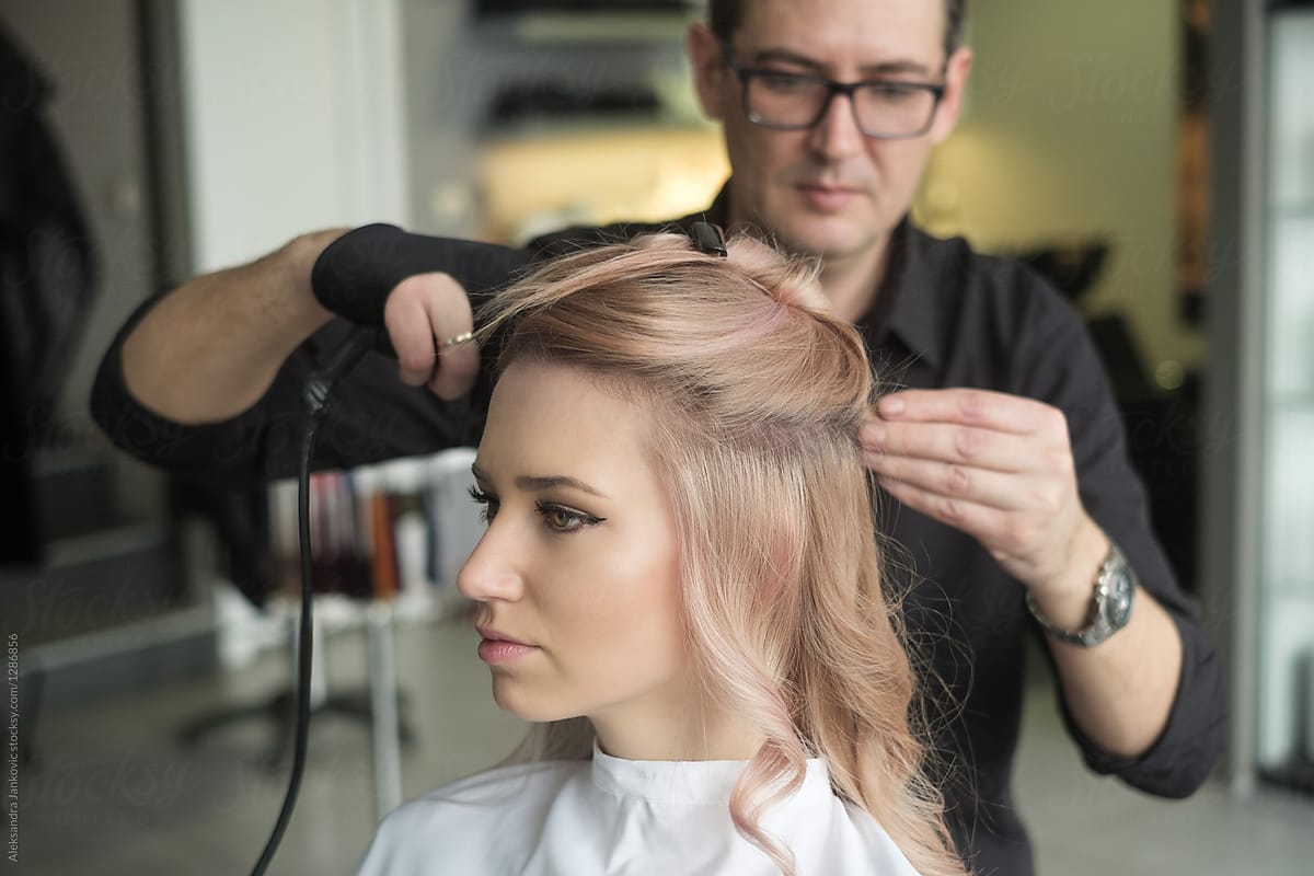 Male Hairdresser Working On A Customer\'s Hair With Curling Iron