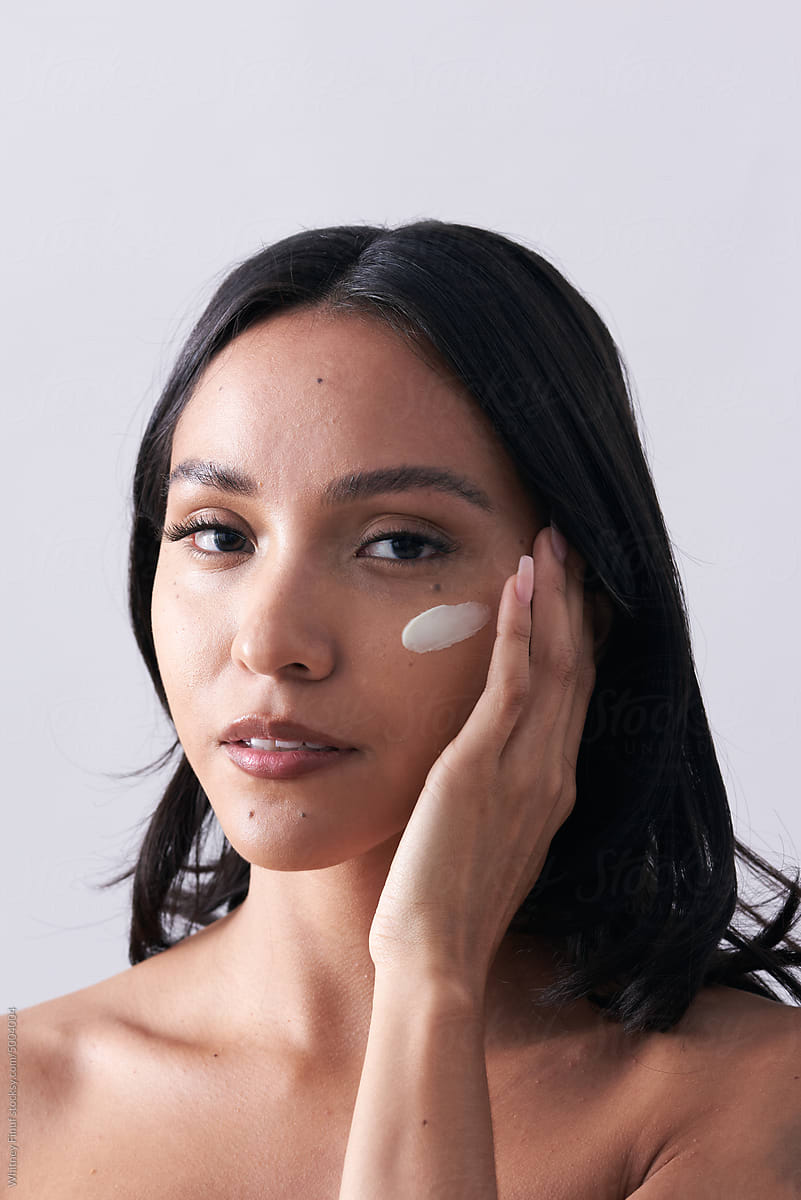 Latina Woman with Creamy Moisturizer Swatch on her Cheekbone