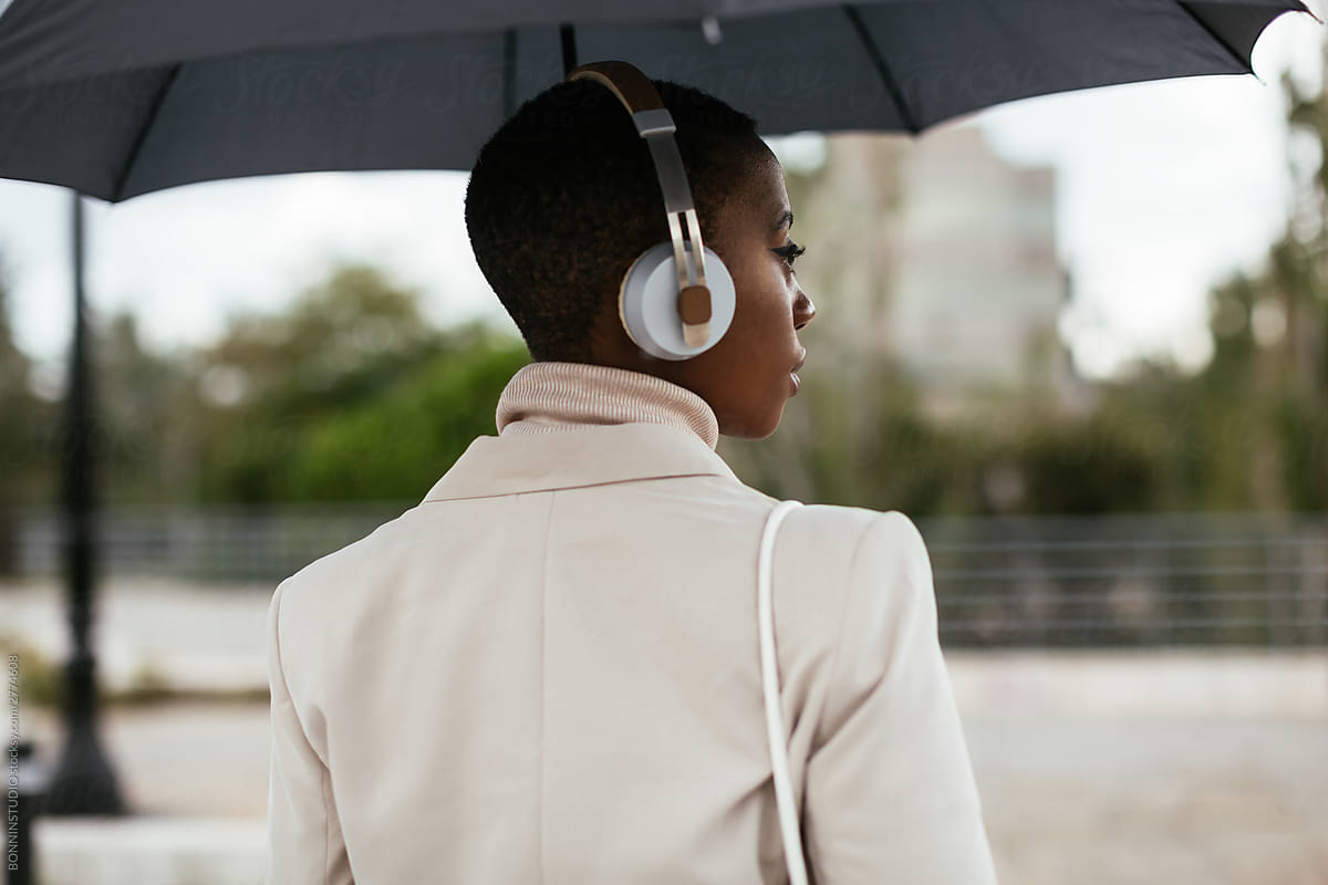 Black female listening to music on rainy day