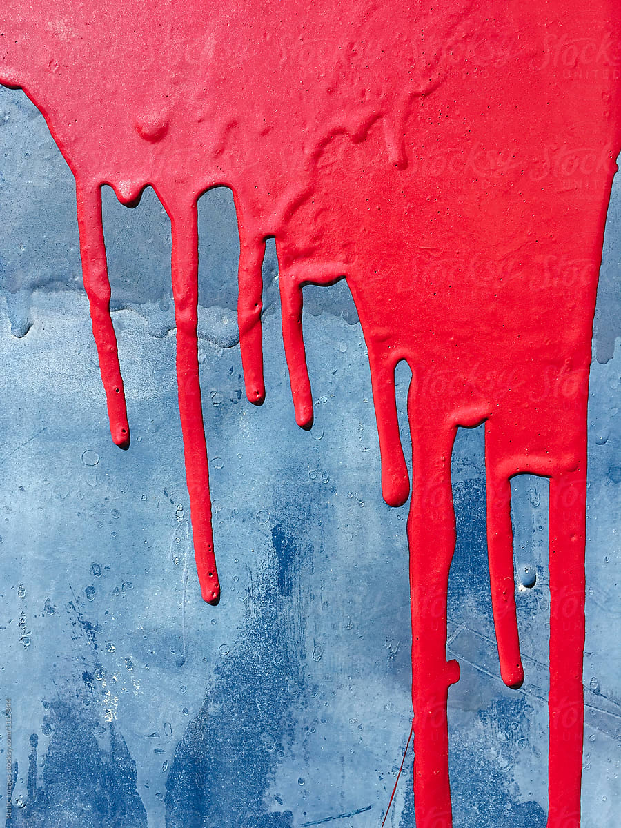 Dripping red graffiti paint on wall, close up