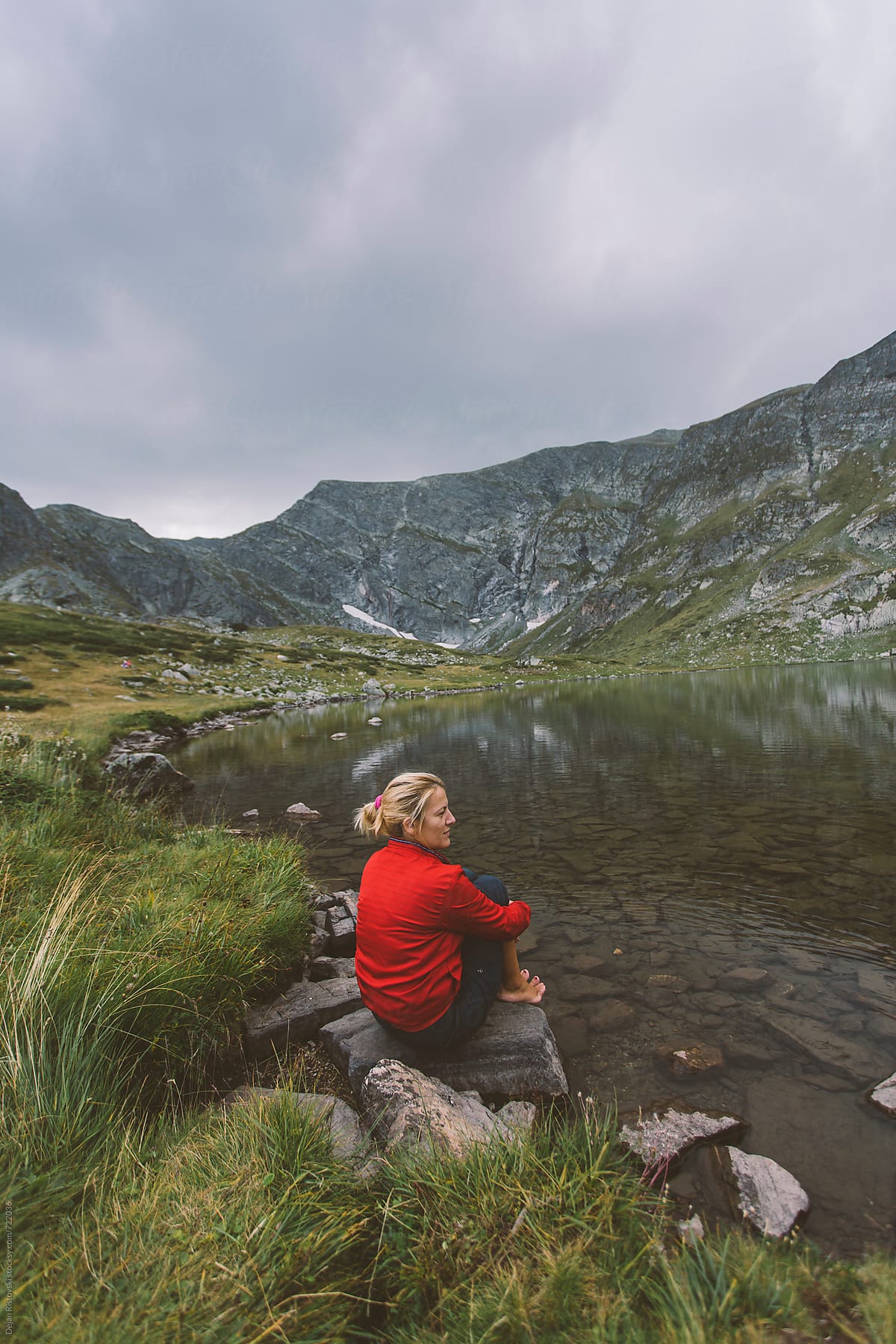 A woman sitting on a mountain lake