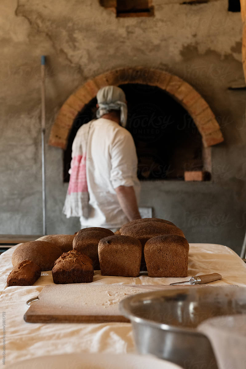 Artisan against stone oven in house