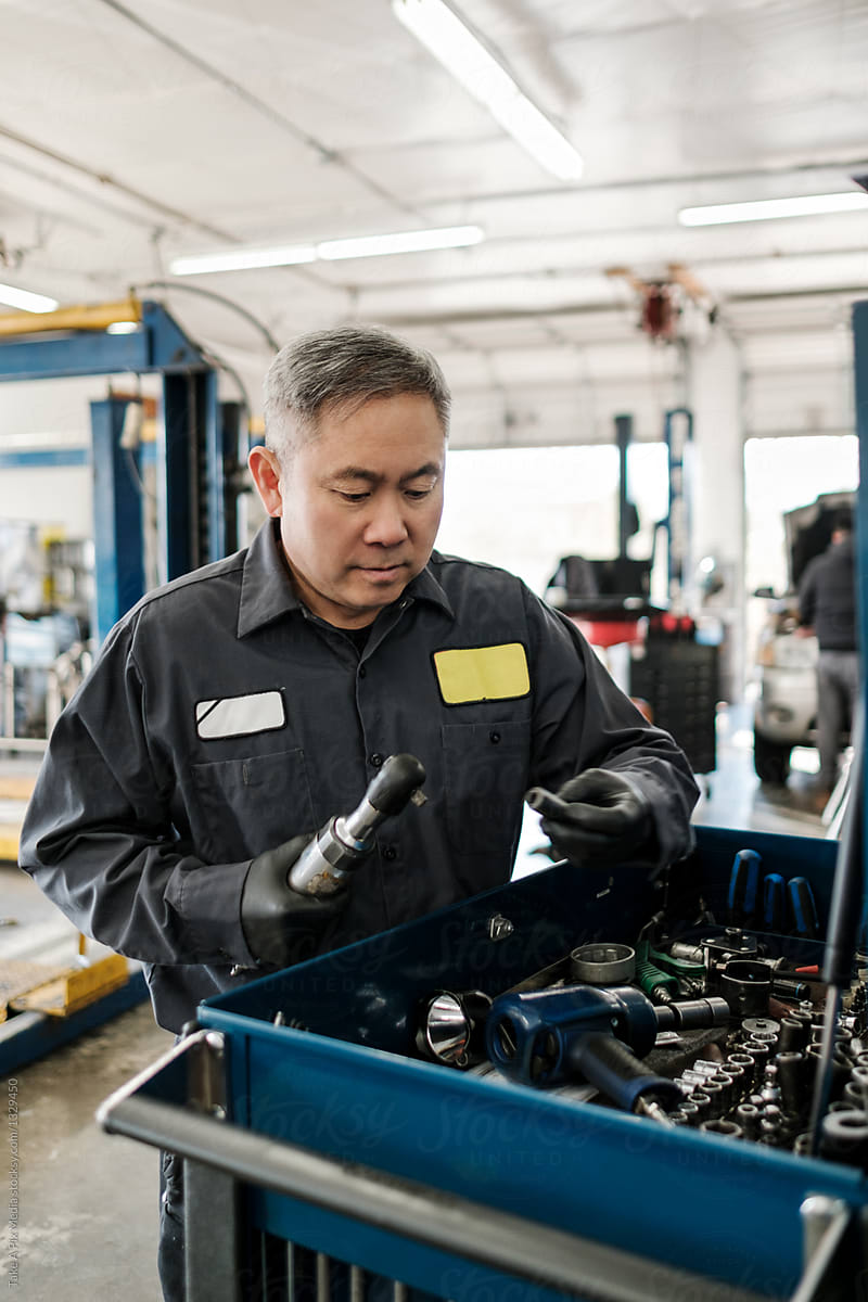 Asian car mechanic working in his auto repair shop