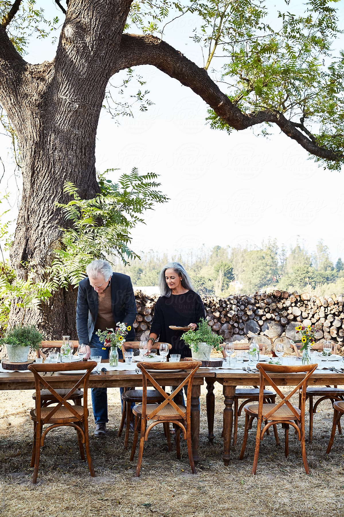 Mature senior couple setting the table for an outdoor dinner party