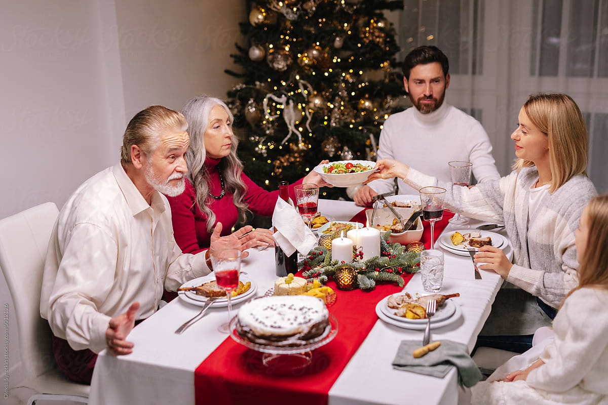 Grandfather grandchild communicate Christmas dinner eating