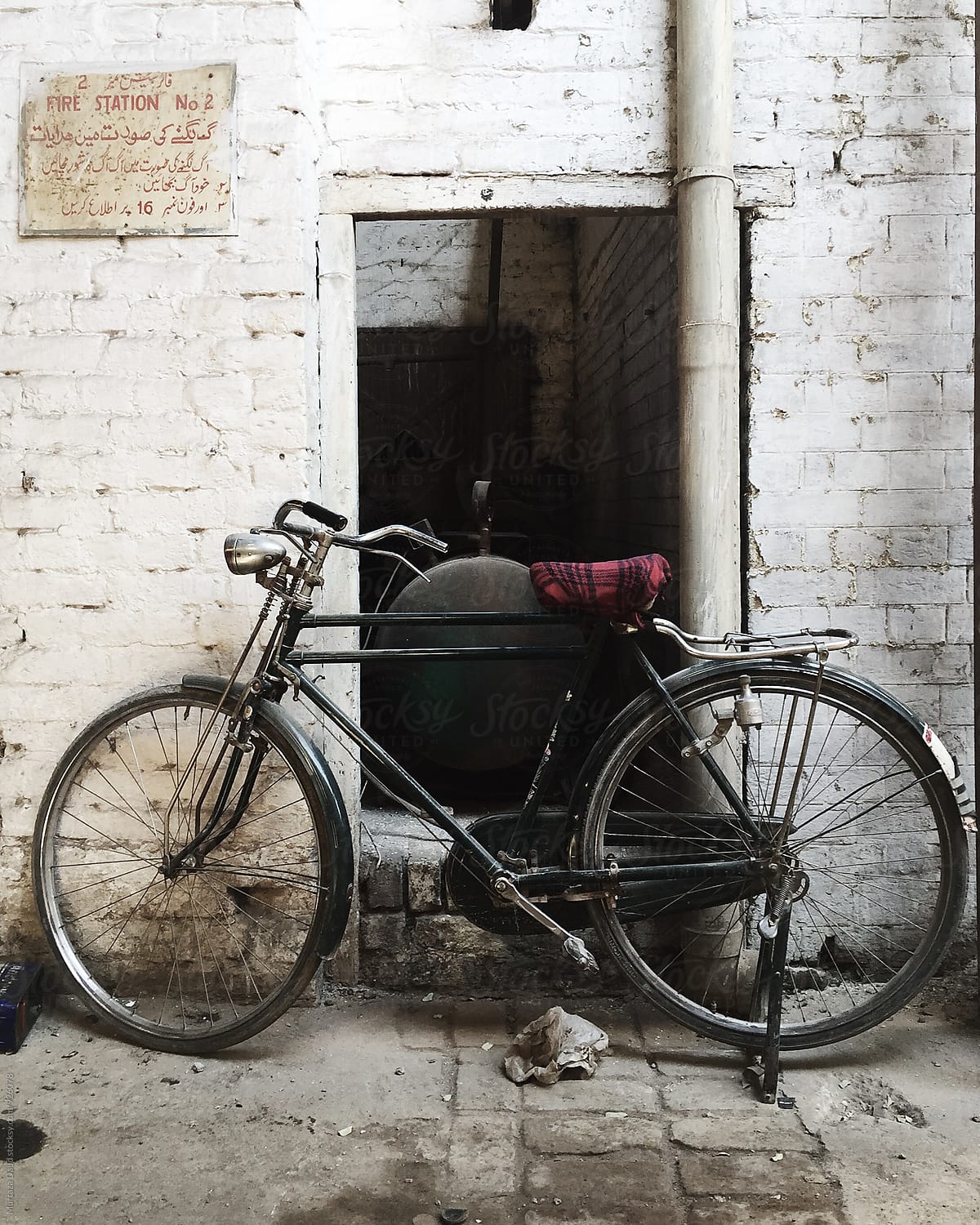 An old bicycle standing against a white wall in a rural area in Pakistan