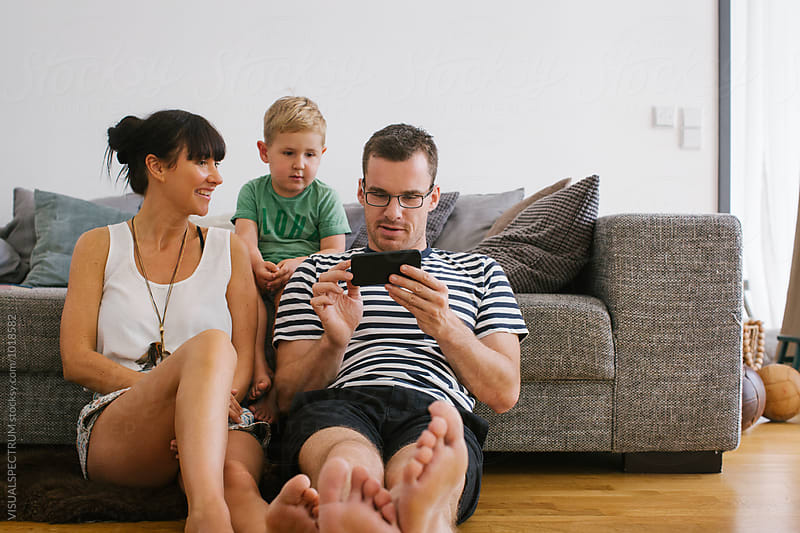 Family at Home - Young Parents With Small Boy Watching Video on Cellphone