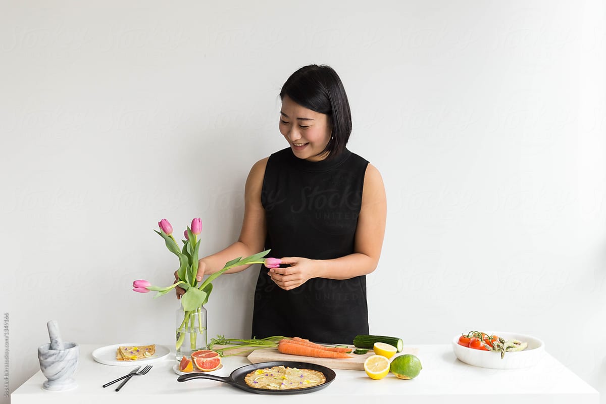 Girl in black outfit prepping food on white table