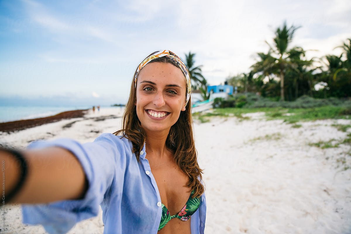 Young Woman Taking A Selfie In A Tropical Beach At Sunset By Stocksy Contributor Alejandro