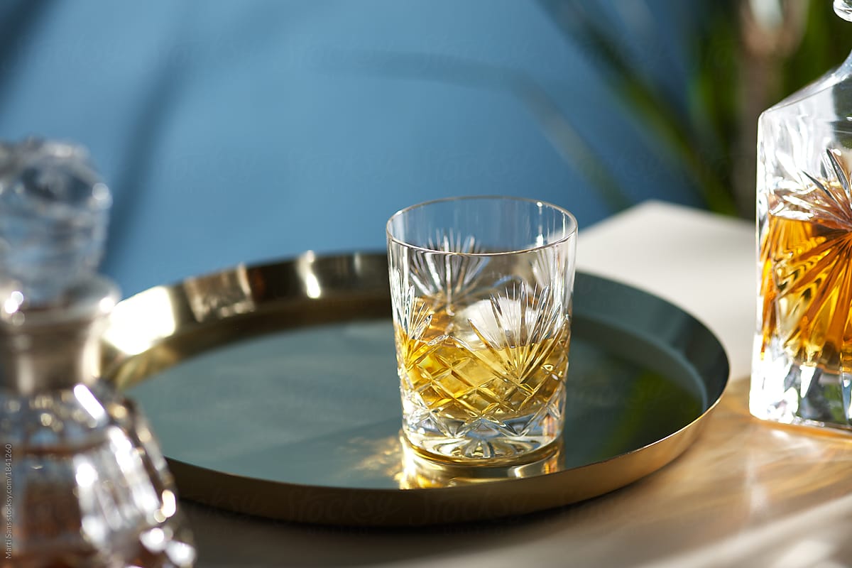 Glass of whisky on tray.
