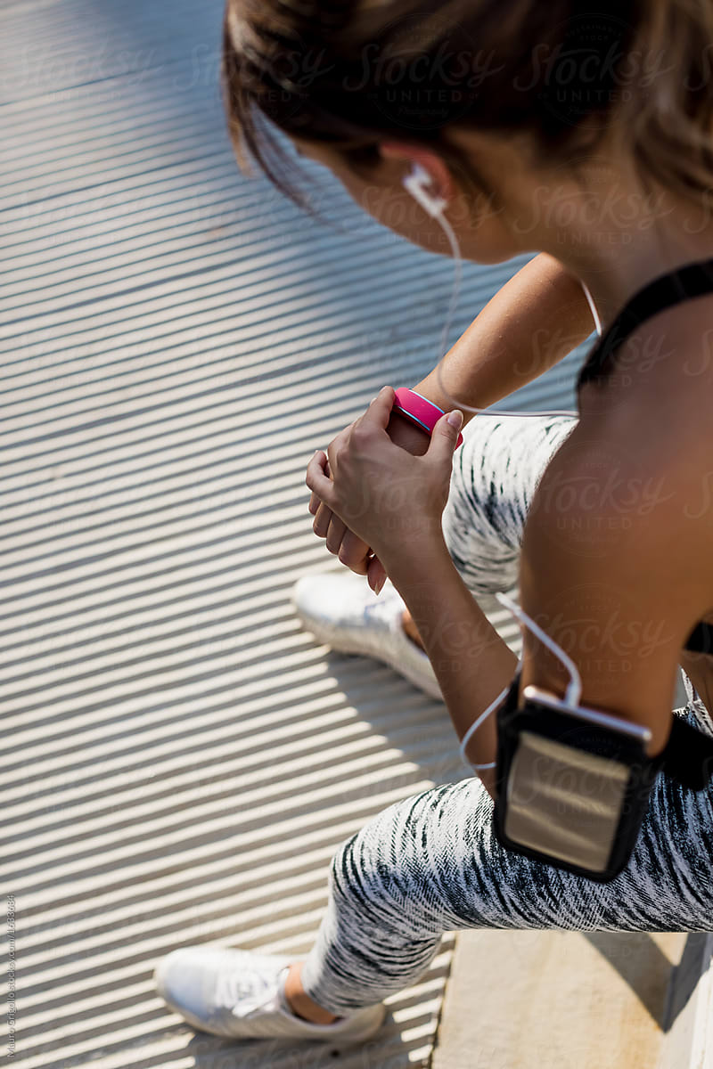 A sporty woman checks her fitness watch during the workout